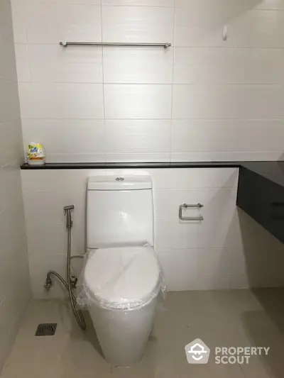 Modern bathroom with sleek design featuring a toilet and minimalistic decor.