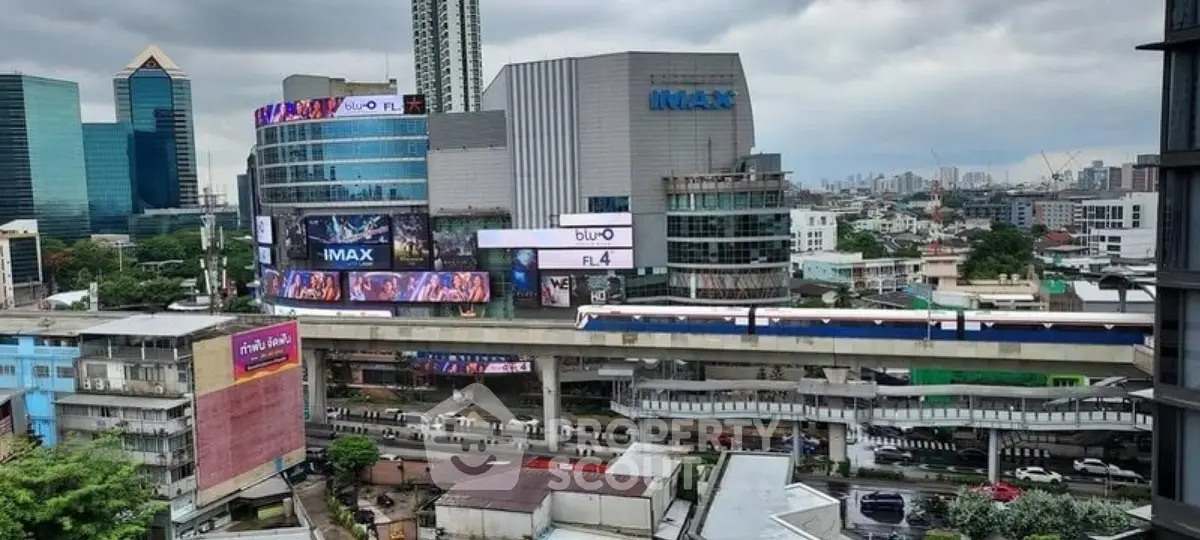 Urban cityscape with modern buildings and elevated train, showcasing vibrant city life.