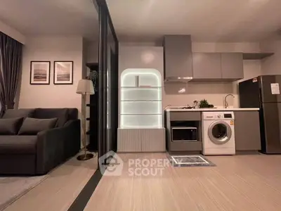 Modern open-plan living room with sleek kitchen and washing machine