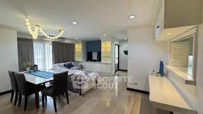 Spacious living room with elegant dining area and modern lighting in a stylish apartment.