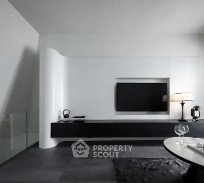 Modern living room with sleek black and white design, featuring a wall-mounted TV and stylish decor.