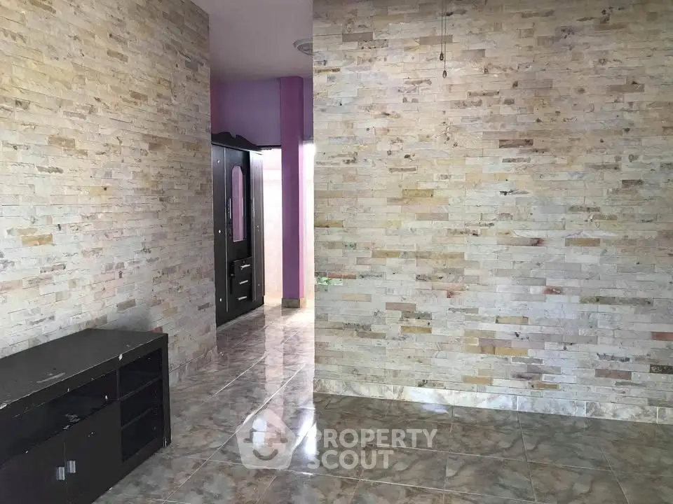 Spacious interior with stone accent walls and glossy tiled flooring, perfect for modern living.
