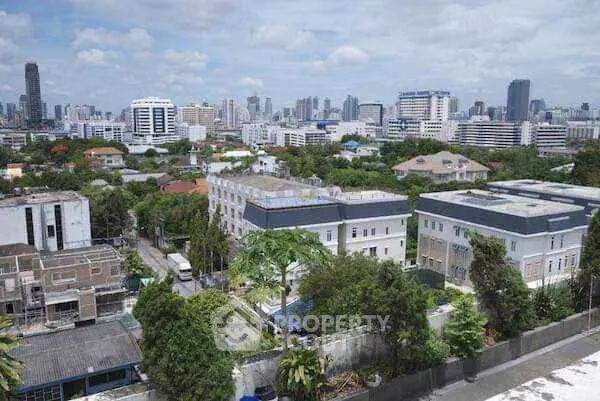 Stunning cityscape view from a high-rise building showcasing urban skyline and lush greenery.