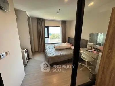 Cozy bedroom with large window and modern decor, perfect for relaxation and comfort.