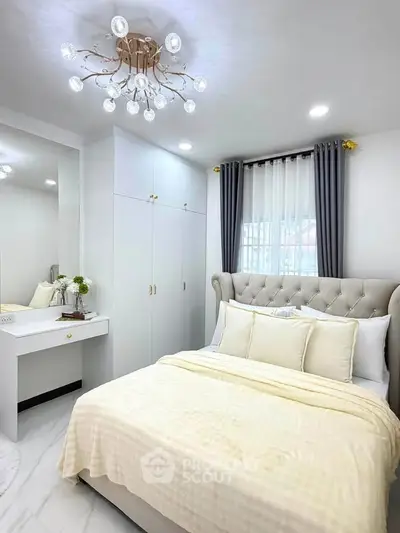 Elegant bedroom with plush bed, modern chandelier, and stylish decor in a bright, airy space.