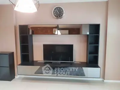 Modern living room with sleek entertainment unit and wall-mounted clock