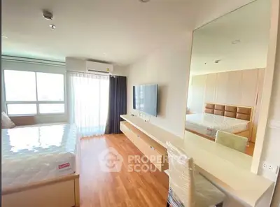 Spacious modern bedroom with large window and wall-mounted TV, featuring sleek wooden flooring.