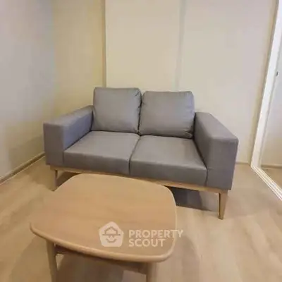 Cozy living room with modern gray sofa and wooden coffee table, perfect for relaxation.