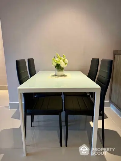 Modern dining area with sleek black chairs and white table, perfect for contemporary living spaces.