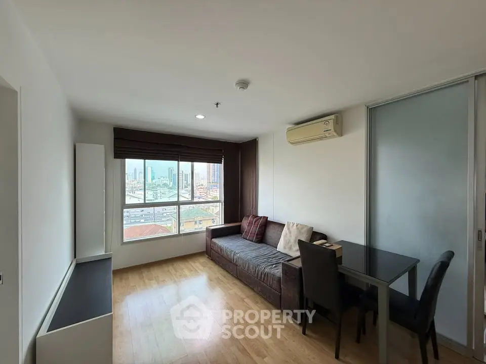 Modern living room with city view, featuring sleek furniture and natural light.