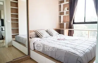 Cozy bedroom with large window and built-in shelves, perfect for natural light lovers.
