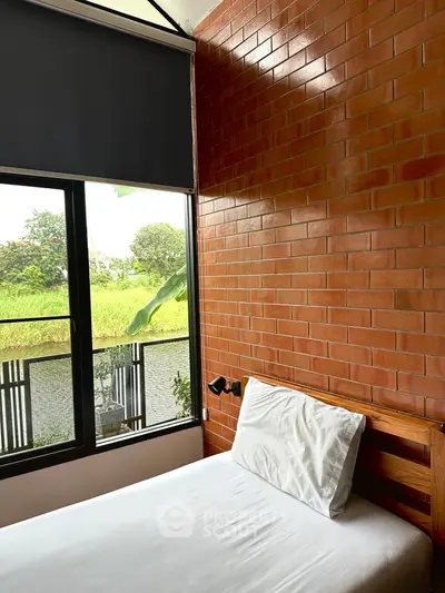 Cozy bedroom with brick wall and scenic window view
