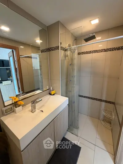 Modern bathroom with sleek vanity and glass shower enclosure