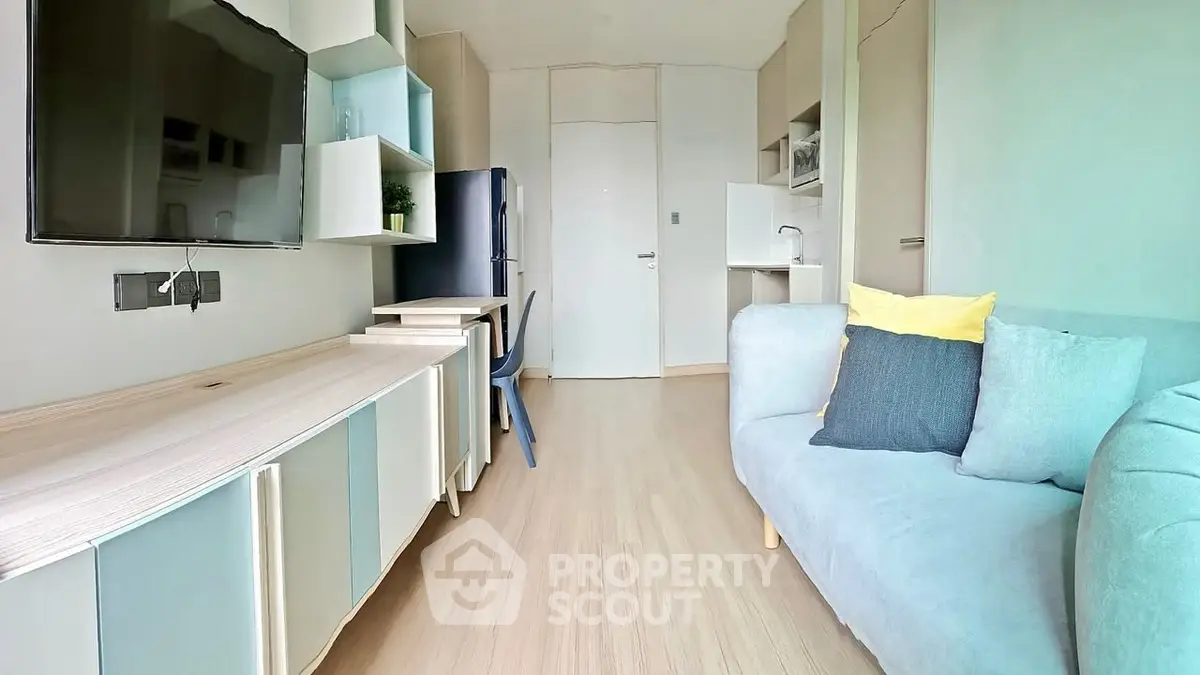 Modern living room with sleek furniture and wall-mounted TV in a cozy apartment.