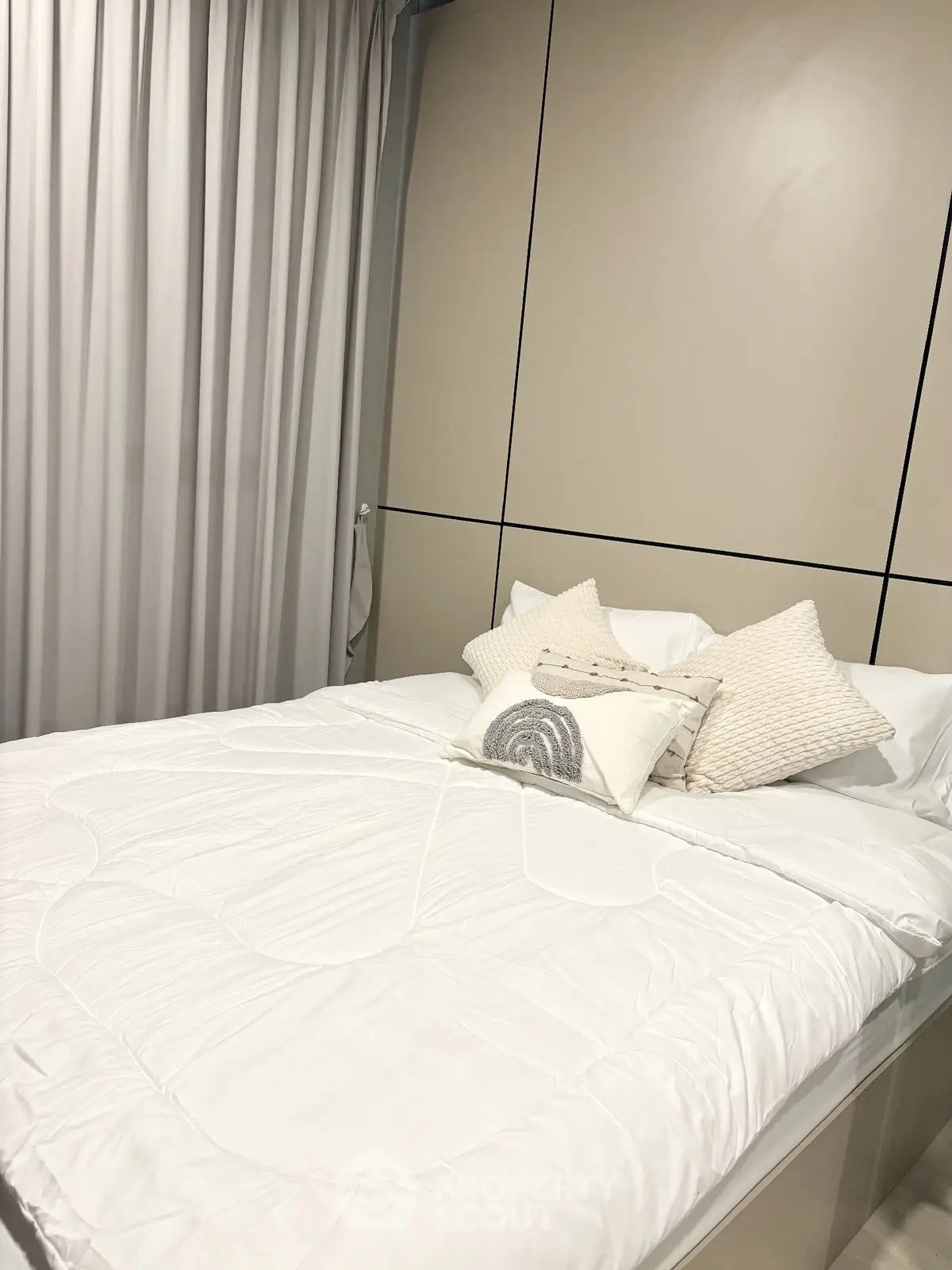 Modern bedroom with elegant decor and cozy bedding in a stylish apartment.