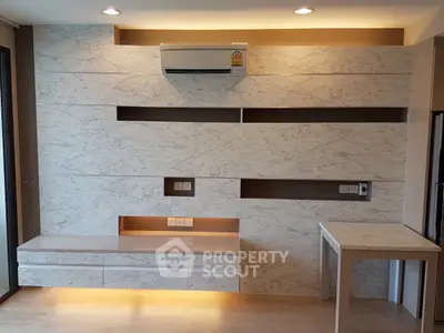 Modern living room with marble accent wall and built-in storage, featuring sleek air conditioning unit.