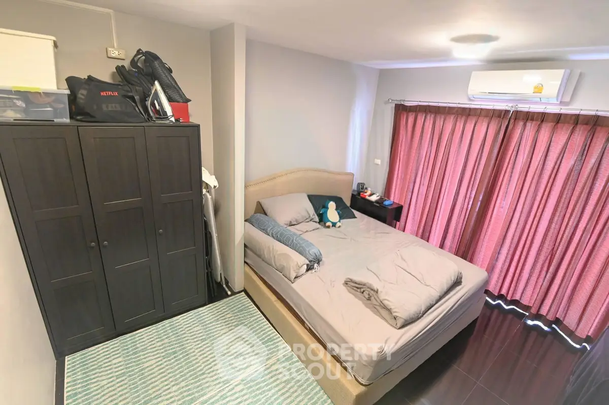 Cozy bedroom with modern decor, featuring a comfortable bed, wardrobe, and air conditioning for ultimate relaxation.