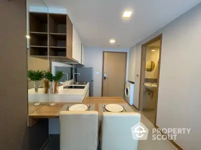 Modern compact kitchen with dining area and washing machine in stylish apartment