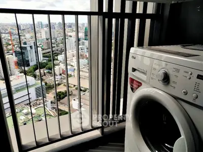 High-rise apartment balcony with city view and washing machine.