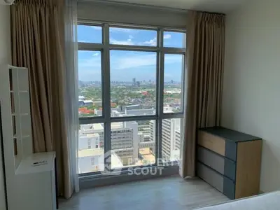 Bright bedroom with large window offering stunning city views.