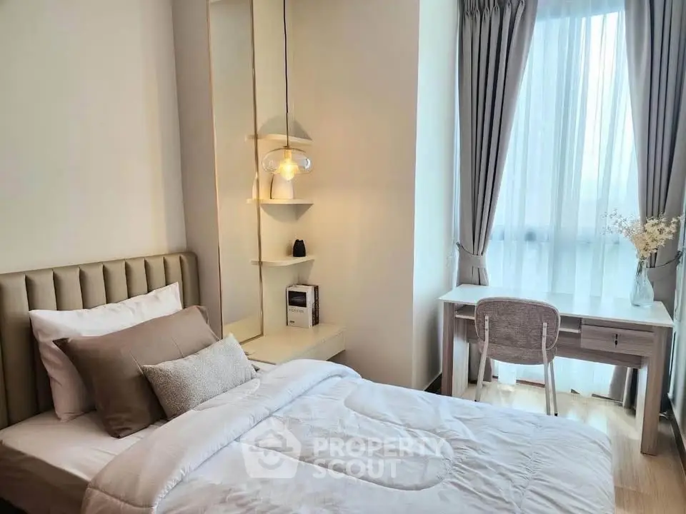 Cozy bedroom with natural light and modern decor, featuring a comfortable bed and stylish workspace.