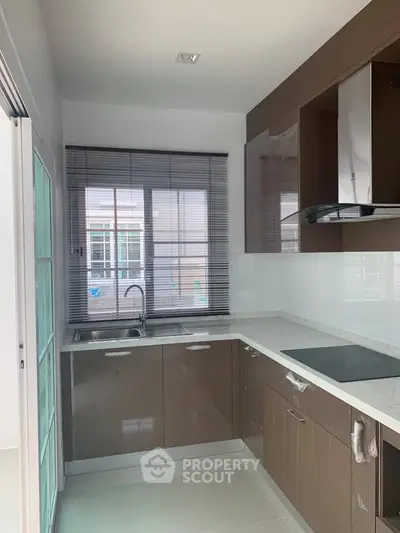 Modern kitchen with sleek cabinets and large window for natural light
