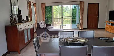 Spacious living room with garden view, elegant furniture, and natural light for a serene ambiance.