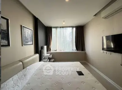 Modern bedroom with large window and wall-mounted TV in a stylish apartment.