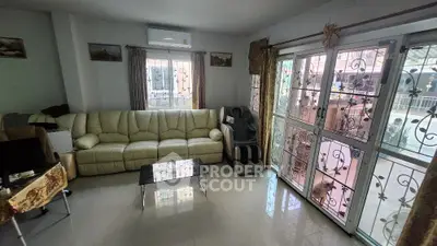 Spacious living room with large windows and comfortable seating in modern home
