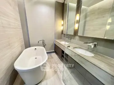 Luxurious modern bathroom with elegant bathtub and sleek vanity in high-end real estate property.