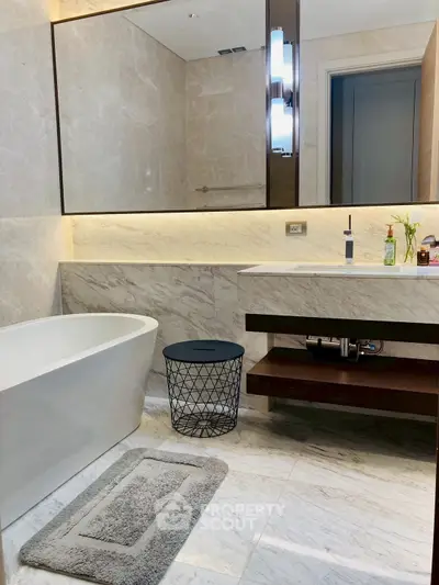 Luxurious modern bathroom with elegant marble finishes and sleek freestanding bathtub.