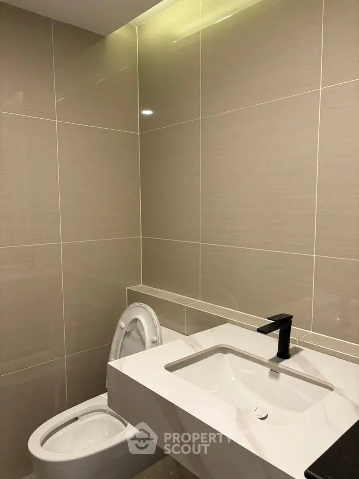 Modern bathroom with sleek fixtures and elegant tile design.