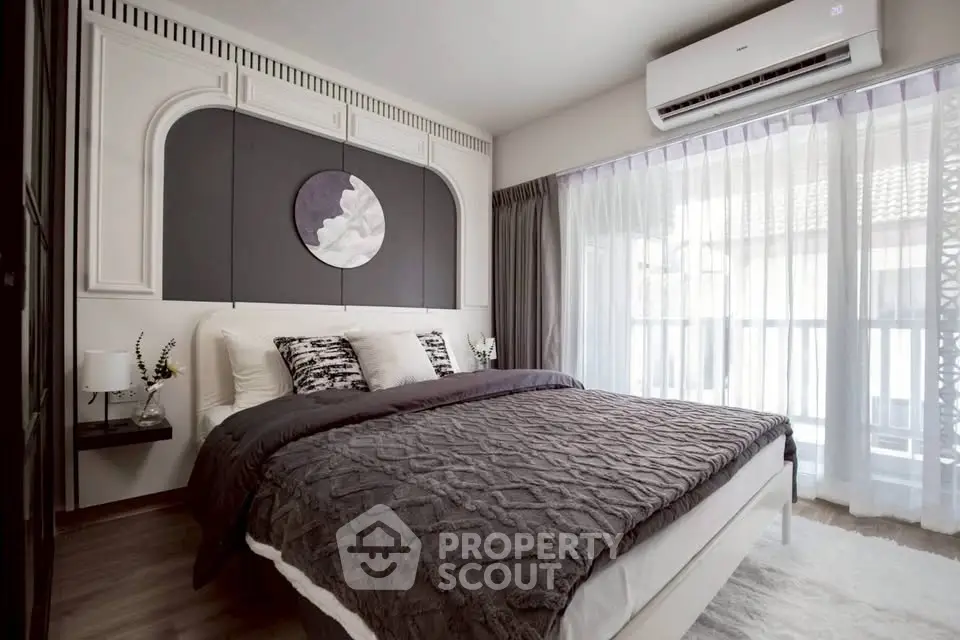 Modern bedroom with stylish decor and large window for natural light