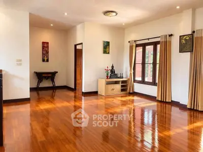 Spacious living room with polished wooden floors and natural light