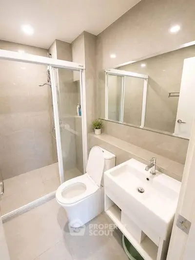 Modern bathroom with glass shower, sleek fixtures, and neutral tiles for a contemporary look.