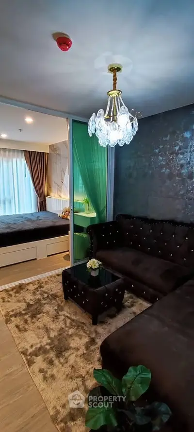 Luxurious living room with plush sofa and elegant chandelier in modern apartment