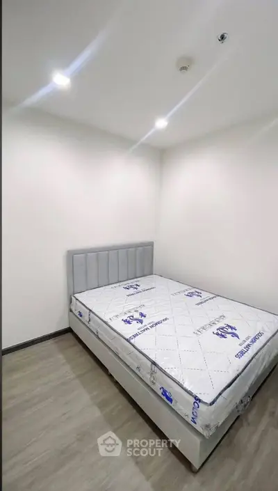 Modern minimalist bedroom with new mattress and sleek flooring