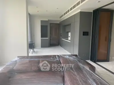 Modern open-layout living room with sleek kitchen and large sofa, perfect for contemporary living.