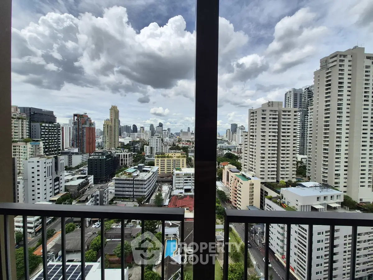 Stunning cityscape view from high-rise balcony with modern skyline and lush greenery.