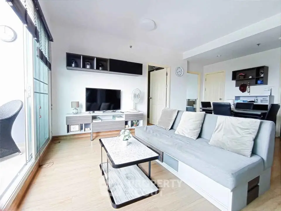 Modern living room with sleek furniture and natural light from large windows.