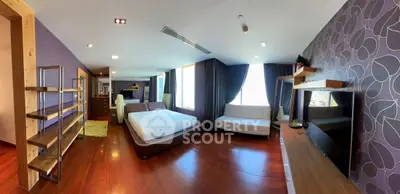 Spacious modern bedroom with stylish decor and large windows for natural light.