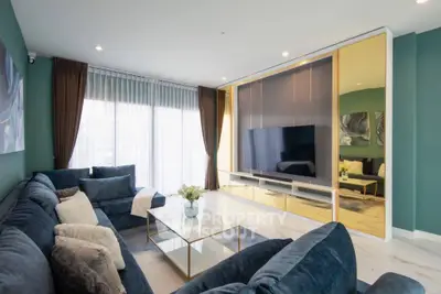 Luxurious living room with plush blue sofa and modern entertainment center