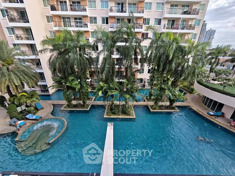 Luxurious apartment complex with stunning pool and lush palm trees, perfect for resort-style living.