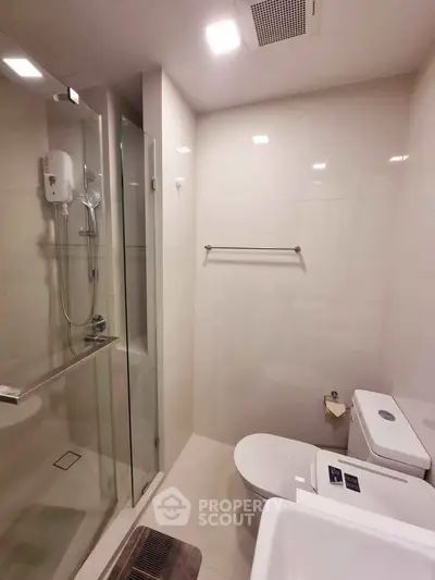 Modern bathroom with glass shower and sleek fixtures in a contemporary apartment.