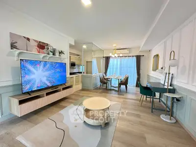 Spacious modern living room with open kitchen and dining area, featuring stylish decor and ample natural light.