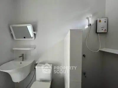 Modern minimalist bathroom with sleek fixtures and wall-mounted shower heater.