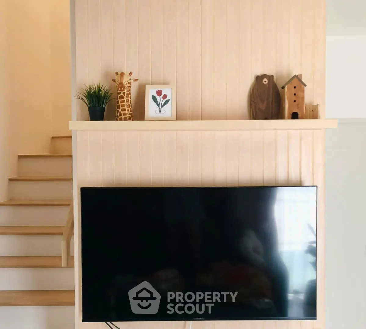 Modern living room with wall-mounted TV and decorative shelf