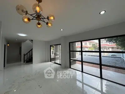 Spacious modern living room with large windows and elegant lighting in a stylish home.