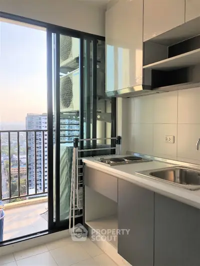 Modern kitchen with balcony view in high-rise apartment