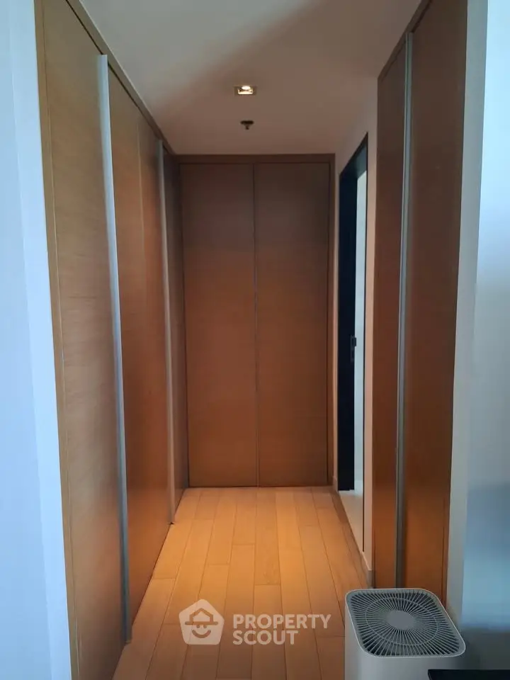 Spacious hallway with wooden paneling and modern design in luxury apartment.